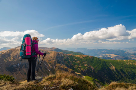 Hiker woman on the mountain top. Vacation, social distancing and isolation in the wild nature