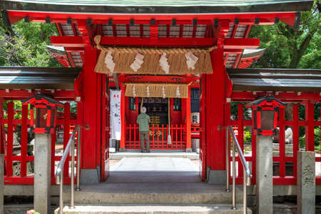 Fukuoka, Japan, May 28 2019, a man praying in ancient Suikyo Tenmangu Shinto shrineのeditorial素材