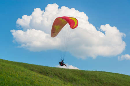 2017-06-25, Kyiv, Ukraine. Red paraglider wing silhouette in the sky with cloudsのeditorial素材