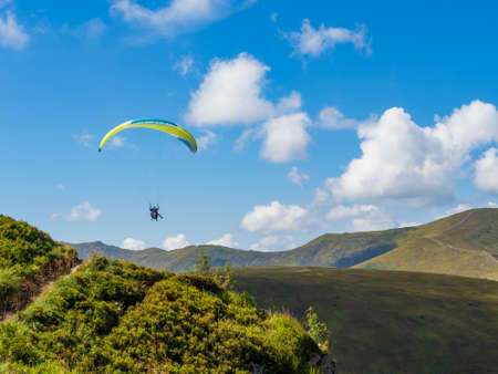 2020-08-23 Borzhava, Ukraine. Bright tandem paraglider high in the mountains. Popular tourist extreme sport activity.のeditorial素材