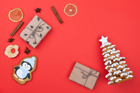 Christmas card with frame made of gingerbread, cookies, presents on red background