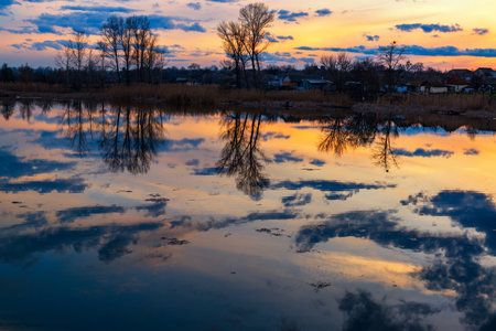 Calm evening on the lake. Sunset sky and trees reflection in the lake. Perfect place for fishing,...