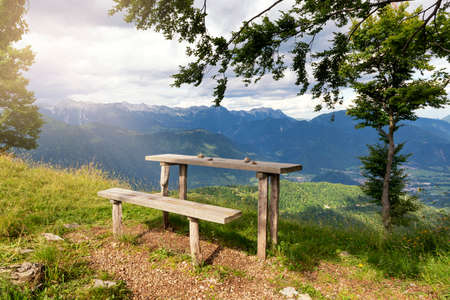 Bench and table in the mountains with view on Alps and alpine valleyの写真素材