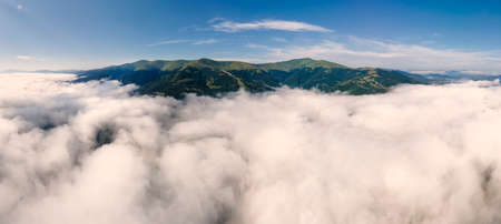 Amazing aerial panoramic view on Borzhava mountain range in the Carpathians with feet covered by cloudsの写真素材