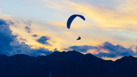 2021-08-17 Meduni, Italy. Paraglider wing with sunset clouds on the background