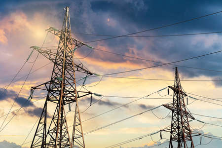 Power line pylons against the dramatic sky. Energy transportation and lack of energy conceptの写真素材