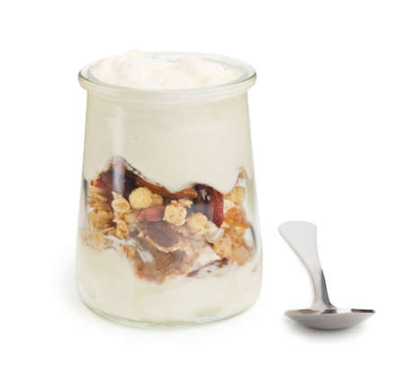 Healthy delicious yogurt with granola and nuts in a glass bowl with spoon on white backgroundの写真素材