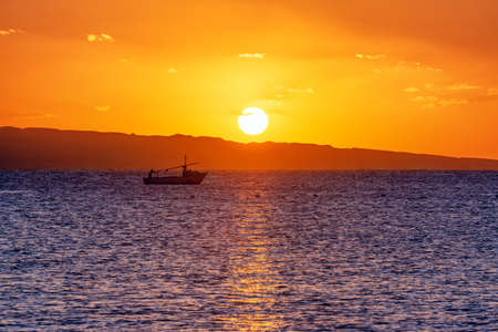 Sunrise on the Red sea with fisherman's boat going for his morning fishingの写真素材