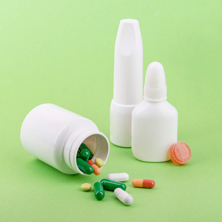 Medicine bottles and pills for respiratory disease therapy. Green background.