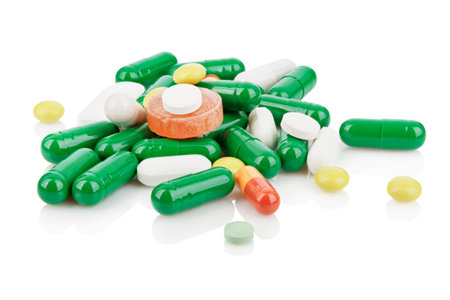 Heap of colorful pills and capsules for medical treatment isolated on white background with...