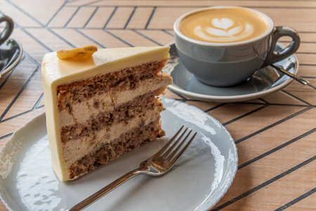 Delicious sweet cake and cup of cappuccino. Tasty dessert on the wooden table.の写真素材