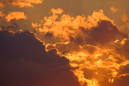 Burning sunset background. Sunset clouds illuminated by golden sun