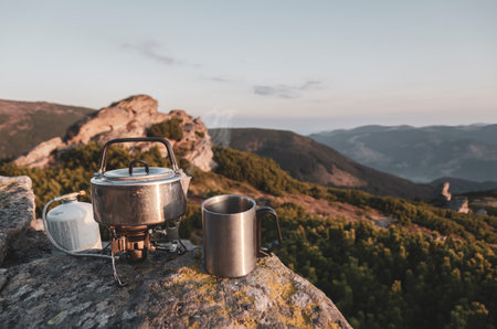 Boiling tea pot on the tourist gas stove high in the mountains. Hot drink with a viewの写真素材