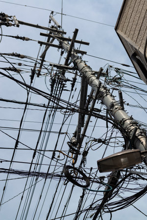 Chaotic web of electric wires in Fukuoka city, Japan. Asian mess of electric cablesの写真素材
