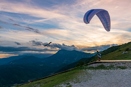 2021-08-17 Meduno, Italy. Paraglider pilot at the take-off for a sunset flightのeditorial素材