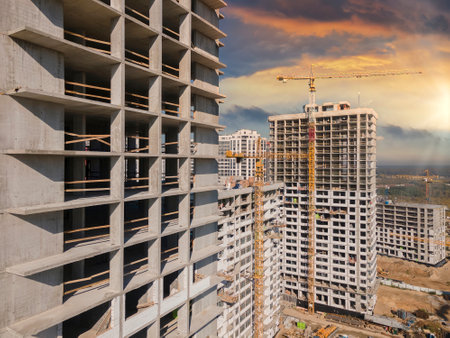Aerial view at construction site on the sunset. Tall buildings and construction cranes.の写真素材