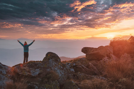 Lone tourist meets mountain sunset. Outdoor activity and exploring conceptの写真素材