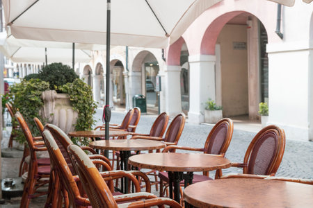 Cozy cafe with wooden chairs on italian street. Vacation in Italy. Typical italian sceneの写真素材