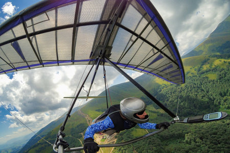 Girl hang glider pilot soars in the mountains on her light kite wing.の写真素材