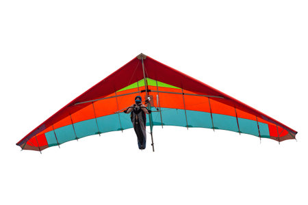Colorful hang glider wing isolated on white. Girl pilot soar on her wing in the skyの写真素材