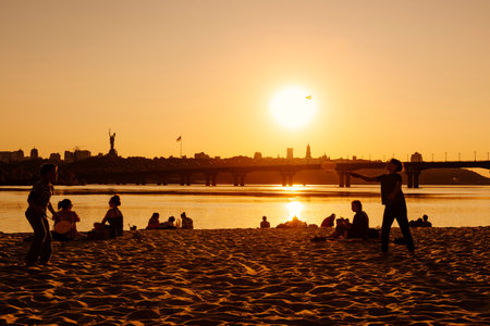 Kyiv, Ukraine, May 2023, boys playing on a beach at sunsetのeditorial素材