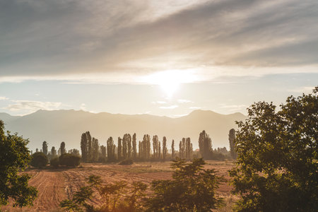 Golden sunset in Macedonia with plowed farm field and mountain silhouettes on the horizonの写真素材