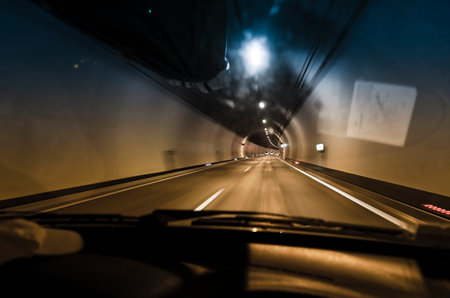 Driving a car in the tunnel. View on highway tunnel with motion blur from the car seat through the windglassの写真素材
