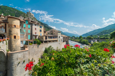Entrevaux. Picturesque little old town in Provence, France. Old city walls, mountains, river and flowers. Postcard from France. Selective focus on flowersのeditorial素材