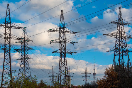 Multiple powerline support towers against the blue sky with clouds. Electricity gridの写真素材
