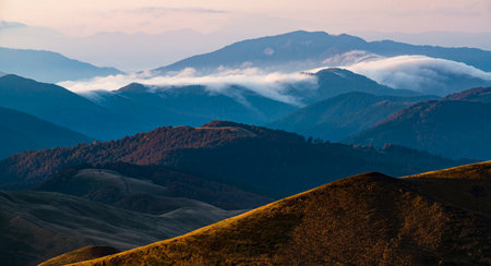 Scenic mountain range panorama. mountain range header. Picturesque hills with clouds in the valleysの写真素材