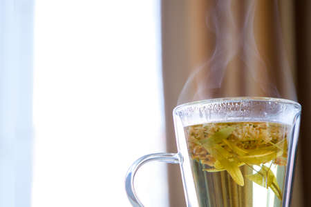 Linden tea on a wooden table in a transparent mug.の写真素材