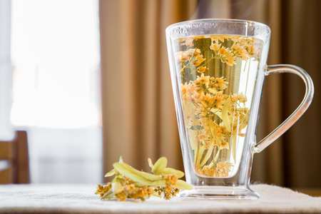 Linden tea on a wooden table in a transparent mug.の写真素材