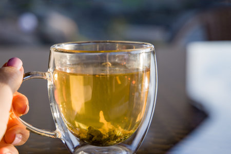 hand holds a cup of herbal tea