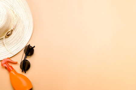 Summer background with place for text. Hat, glasses and sunscreen on an orange background