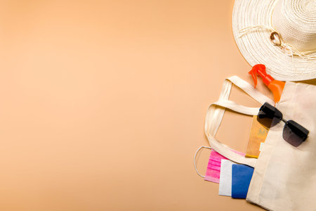 Summer background. Summer vacation concept. Glasses, hat, sunscreen, passport on an orange...