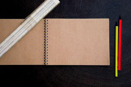 notebook with ruler and pencils on a dark backgroundの写真素材