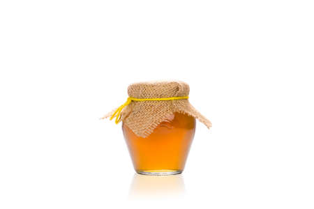 Jar of honey isolated on a white background.の写真素材