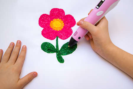 The child draws leaves with a 3D pen. The flower is printed with a 3D pen.の写真素材