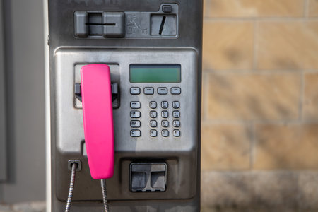 An old telephone machine with a pink handset. street phone.の写真素材