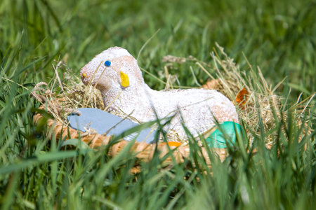 Easter lamb cake in a wicker basket hidden in the grass.の写真素材