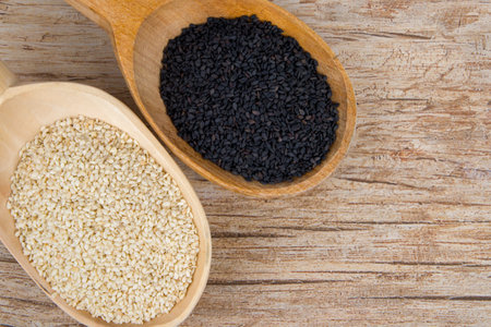 Black and white sesame seeds in a wooden bowl.の写真素材