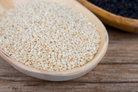 White sesame in a wooden spoon close-up.の写真素材