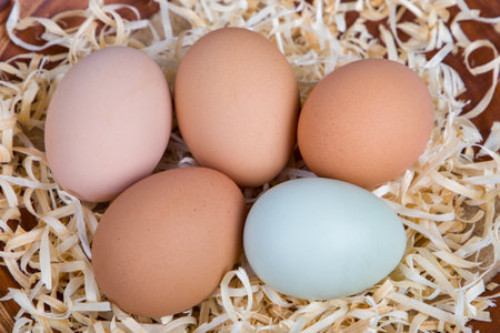 Close up of fresh eggs in a basket on a wooden background.の写真素材