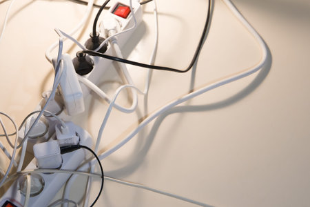 Electric extension cords with a switch. Many chargers are on. Selective focus. Top view.