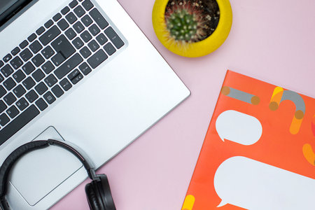 Top view of work space with laptop and headphones on pink backgroundの写真素材
