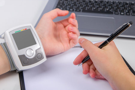 woman hand using a measuring level with blood pressure monitorの写真素材
