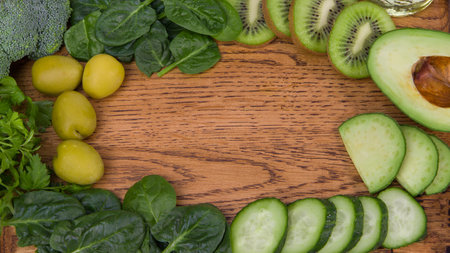 a wooden table with a variety of green fruits and green vegetables. Copy space.の写真素材