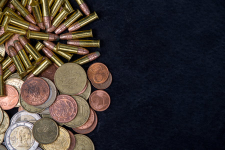 Coins and bullets on black background. Money concept. Top view.