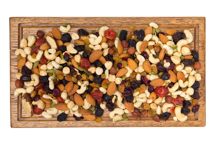 Mix of nuts and dried fruits in wooden tray isolated on white background