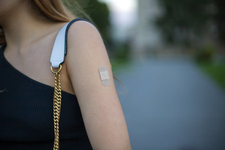 Woman with adhesive bandage on her arm after vaccination. Selective focus.の写真素材